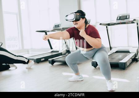 Frauen in Übergröße, die VR-Headset verwenden, genießen visuelle Sport-Fitness-Spielübungen. Menschen, die moderne Technik für das Heilbehandlungskonzept nutzen. Stockfoto