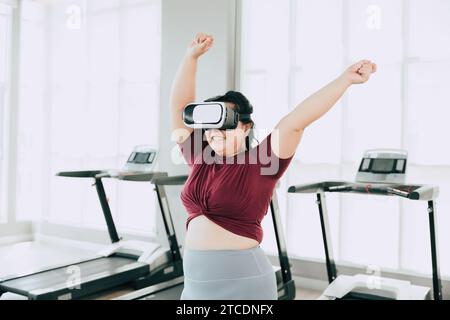 Frauen in Übergröße, die VR-Headset verwenden, genießen visuelle Sport-Fitness-Spielübungen. Menschen, die moderne Technik für das Heilbehandlungskonzept nutzen. Stockfoto