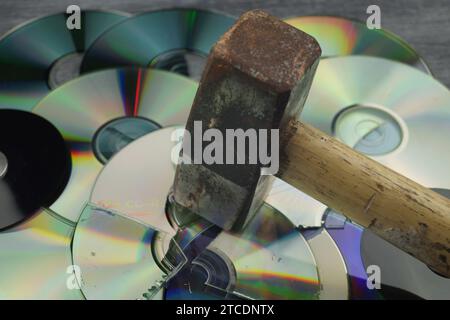 Zerstörte DVDs und Hammer, Symbolbild für Hackerangriffe Stockfoto