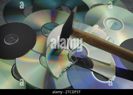 Zerstörte DVDs und Hammer, Symbolbild für Hackerangriffe Stockfoto