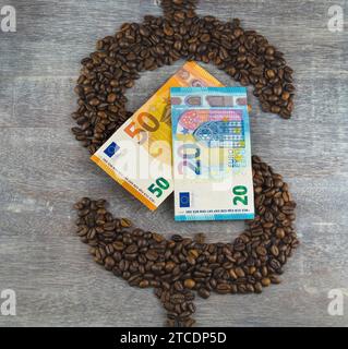 Dollarzeichen, gebildet aus gerösteten Kaffeebohnen, mit Euroscheine, Kaffeepreis Stockfoto