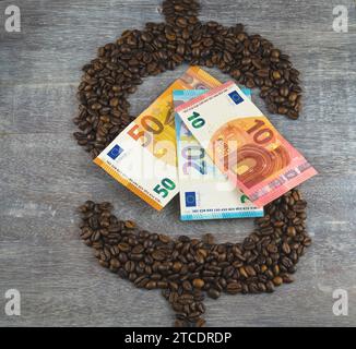 Dollarzeichen, gebildet aus gerösteten Kaffeebohnen, mit Euroscheine, Kaffeepreis Stockfoto