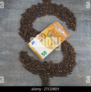 Dollarzeichen, gebildet mit gerösteten Kaffeebohnen, mit Euro-Rechnung, Kaffeepreis Stockfoto