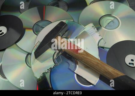 Zerstörte DVDs und Hammer, Symbolbild für Hackerangriffe Stockfoto