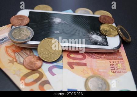 Handy mit defektem Display und Euro, Symbolbildkosten für Handy Stockfoto