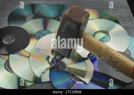 Zerstörte DVDs und Hammer, Symbolbild für Hackerangriffe Stockfoto