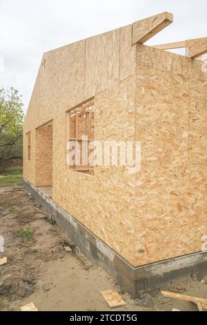 Vorgefertigte Baustelle aus Holzhäusern, Holzbalkenbalken und Holzspanplatten, selektiver Fokus Stockfoto