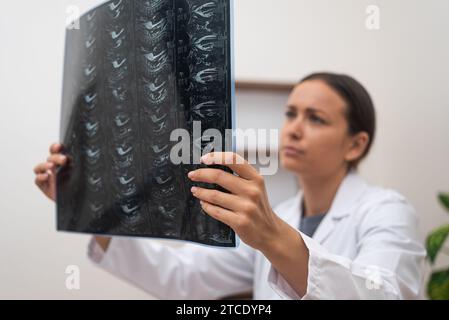 Nahaufnahme Orthopädie bewertet Röntgenfilme des Patienten und MRT-Scans sehen besorgt aus. Stockfoto