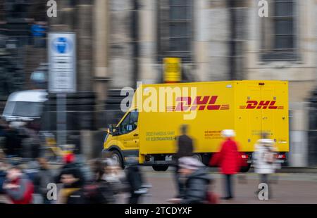 Dresden, Deutschland. Dezember 2023. Morgens fährt ein Elektrobus vom DHL-Paket- und Briefexpress über den Theaterplatz in der Altstadt. (Aufnahme mit langer Belichtungszeit) Darlehenswort: Robert Michael/dpa/Alamy Live News Stockfoto