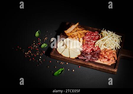 Blick aus einem hohen Winkel auf die Wurstplatte mit Gourmet-Käseauswahl, getrocknetem Rindfleisch und Salamischeiben Stockfoto