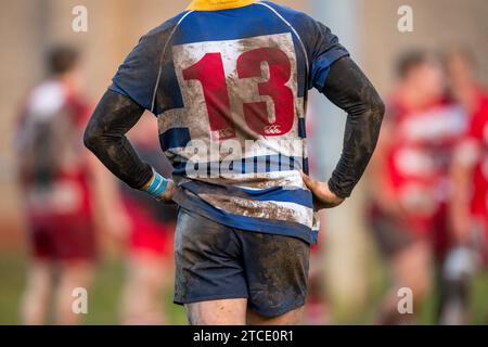 Englischer Amateur-Rugby-Union-Spieler mit einem dreckigen und matschigen Nummer 13-Shirt. Stockfoto