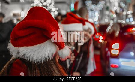 Eine Gruppe glücklicher, nicht erkennbarer Frauen in santa Hats in London während der Festtage. Stockfoto