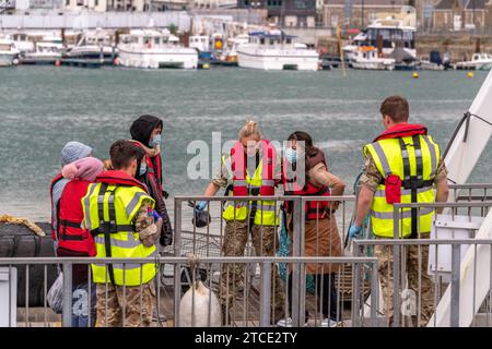 Eintreffende Migranten, Hafen von Dover, Kent, Großbritannien. Juni 2022. Mitglieder der Royal Navy helfen Migranten an Land, die bei der Überquerung der CH abgefangen wurden Stockfoto