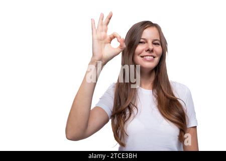 Die junge Frau zeigt eine gute Geste und lächelt süß Stockfoto