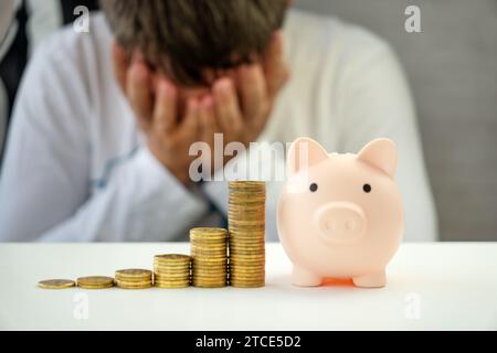 Depressiver Kerl. Probleme Mit Der Wirtschaft, Probleme Mit Der Haushaltsplanung, Finanzkrise. Ein Verärgerter Mann, Der Münzen Aus Der Piggy Bank Zählt, Stockfoto