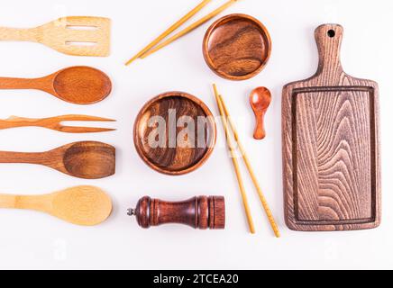 Leere Holzschalen, Sushi-Sticks, Schneideküchenbrett und verschiedene hölzerne Küchenutensilien auf weißem Hintergrund. Flache Lagen. Draufsicht. Layout. Stockfoto