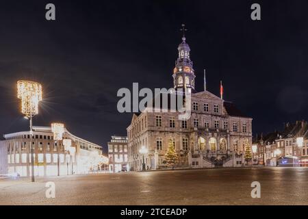 Marktplatz mit seinen typischen Kopfsteinpflastersteinen in Maastricht, beleuchtet mit Weihnachtslichtern und mit Blick auf die Minckeleers-Statue und das Rathaus Stockfoto