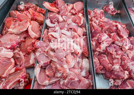 Verschiedene Stücke von Schweinefleisch Steaks, verschiedene Körperteile, die Fleisch zum Verkauf in Behältern an einer Ladentische schneiden Stockfoto