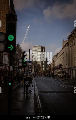 Navigieren Sie durch die Winterstraßen von London, und gehen Sie auf dem Bürgersteig inmitten des starken Verkehrs. Das geschäftige Treiben in der Stadt sorgt für eine dynamische Szene Stockfoto