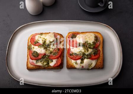 Toast mit Mozzarella, Tomaten und Pesto-Sauce. Warmes Frühstück im Ofen mit einer Tasse Kaffee. Traditionelles Gericht, Hausmannskost. Selektiv Stockfoto