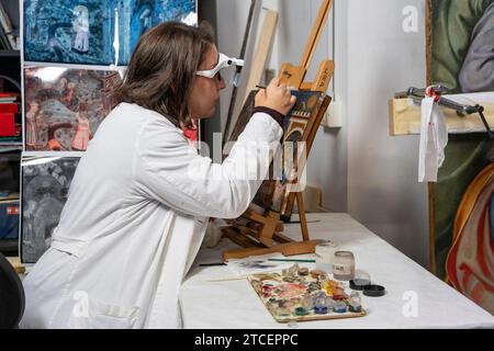 Vatikanstadt, Vatikan. Dezember 2023. Die Restauratorin Chiara Notarstefano arbeitet an einem Gemälde im Labor für die Restaurierung von Gemälden und Holzmaterialien in den Vatikanischen Museen. „Beyond the surface: The Restauration's Gaze“ ist der Titel der Ausstellungsinitiative, mit der die Vatikanischen Museen das hundertjährige Jubiläum der Gründung des Labors zur Restaurierung von Gemälden und Holzmaterialien feiern. Quelle: SOPA Images Limited/Alamy Live News Stockfoto