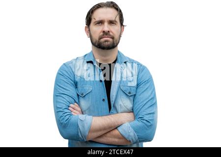 Ernster junger erwachsener Mann mit überkreuzten Armen, lässig gekleidet. Stockfoto