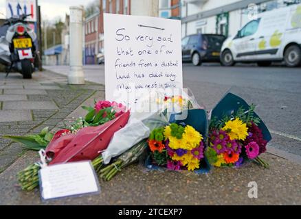 Die Blumen werden am Eingang des Portlandhafens in Dorset nach dem Tod eines Asylsuchenden an Bord des Bibby Stockholm Beherbergungskahns hinterlassen. Die Polizei wurde zu Berichten über einen „plötzlichen Tod“ eines Mannes gerufen, der früh am Dienstagmorgen auf dem riesigen Schiff lebte. Bilddatum: Dienstag, 12. Dezember 2023. Stockfoto