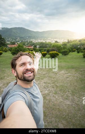 Junger Mann macht ein Selfie in einem wunderschönen Naturpark. Stockfoto