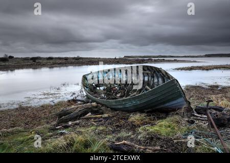 Ein verlassenes hölzernes Fischerboot auf den Sanddünen in der Mündung des Flusses Esk, St Cyrus, Aberdeenshire, Schottland Stockfoto