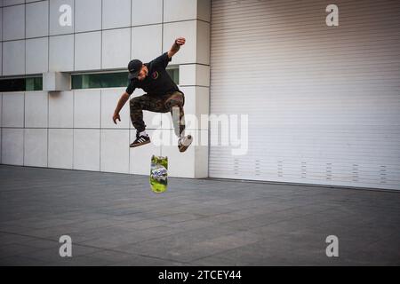 Ein Typ auf einem Skateboard, der auf einer Straße in Barcelona Tricks macht Stockfoto