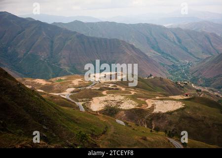 Eine gewundene Straße schlängelt sich durch die üppigen, sanften Hügel einer bergigen Landschaft und bietet eine Reise durch die Pracht der Natur. Stockfoto