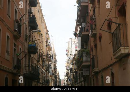 Zwei gegenüberliegende Gebäude in Barcelona mit Fenstern, Pflanzen und Blumentöpfen, Fahnen und Stockfoto