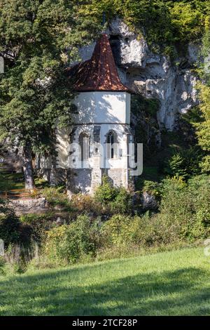 Alte Wallfahrtskirche St. Wendel am Stein direkt am Berg mit Bäumen im Sommer Stockfoto