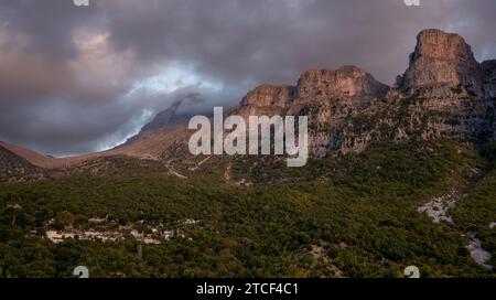 Drohnenlandschaft mikro Papingo Dorf, Zagorochoria Gegend, Epirus, Ioannina Griechenland. Astraka Turm felsige Klippen über dem Dorf bei Sonnenuntergang Stockfoto