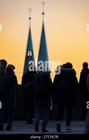 Touristen genießen den Sonnenuntergang über Nürnberg über die Aussichtsplattform auf der Nürnberger Kaiserburg, im Hintergrund die beiden Kirchtürme der Nürnberger Sebalduskirche, welche unterhalb des Burgbergs in der Innenstadt liegt. *** Touristen genießen den Sonnenuntergang über Nürnberg von der Aussichtsplattform auf der Nürnberger Kaiserburg mit den beiden Türmen der Nürnberger St. Sebalds-Kirche im Hintergrund, die sich unterhalb des Schlosshügels im Stadtzentrum befindet 20230107-6V2A0695 Stockfoto