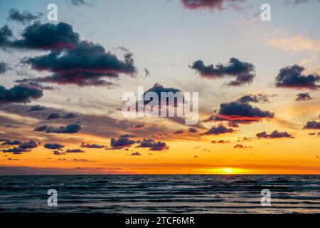 Ein wunderschöner mehrfarbiger goldener Sonnenuntergang am Ufer der Ostsee, goldener Sonnenuntergang am Meer Stockfoto