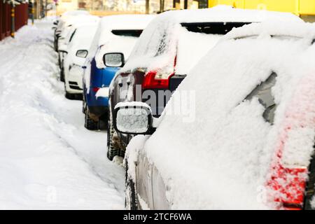 Eine Reihe von geparkten, verschneiten Autos auf der verschneiten Straße, Autos mit Neuschnee Stockfoto