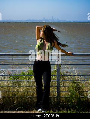 Windy Wind Blown Young Asian Woman Curvy Athletic Standing mit San Francisco Bay im Hintergrund Stockfoto