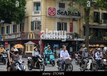 VIETNAM, Hanoi, french Quarter, SeaBank und McDonalds Fast Food Restaurant, Verkehr während der Hauptverkehrszeit, Zweirad Stockfoto