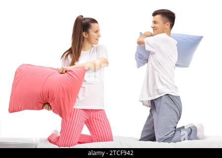 Junger Mann und Frau im Pyjama kämpfen mit Kissen isoliert auf weißem Hintergrund Stockfoto