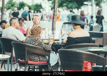 Bukarest, Rumänien - 13. August 2023: Urbane Szene mit Menschen, die an Tischen sitzen und einen Drink auf der Victory Street (Calea Victoriei) im Zentrum von genießen Stockfoto