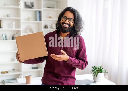 Fröhlicher Junger Indianer, Der Große Karton Zu Hause Hält, Stockfoto