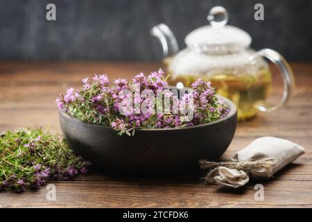 Schüssel mit Thymian-Heilkräutern, Beutel mit Thymus serpyllum-Heilkräutern. Glas-Teekessel von Thymian gesundem Kräutertee auf Hintergrund. Alternat Stockfoto