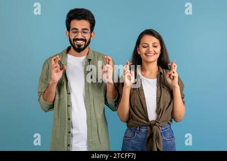 Aufgeregtes tausendjähriges indianerpaar, das die Daumen drückt Stockfoto