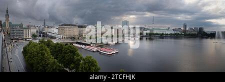 01.07.2023, Hamburg, Hansestadt Hamburg, DE - Blick vom Ballindamm auf die Binnenalster und das Rathaus. Abend, Abends, Alster, Ausblick, Ausflugsziel, Aussen, Aussenaufnahme, Aussicht, Ballindamm, Binnenalster, City, Daemmerung, deutsch, Deutschland, Duester, Duesternis, dunkle Wolken, Europa, europaeisch, Ferne, Fernsicht, Gebaeude, Gewaesser, Haeuser, Hamburg, Hamburger Rathaus, Hansestadt Hamburg, Horizont, Innenstadt, Jahreszeit, Landschaft, Panorama, Panoramaaufnahme, QF, Querformat, Rathaus, Regenwetter, Reise, Schlechtwetter, Sommer, Stadt, Stadtansicht, Stadtbild, Stadtlandschaft, Ue Stockfoto