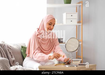 Reife muslimische Frau, die zu Hause Make-up macht Stockfoto