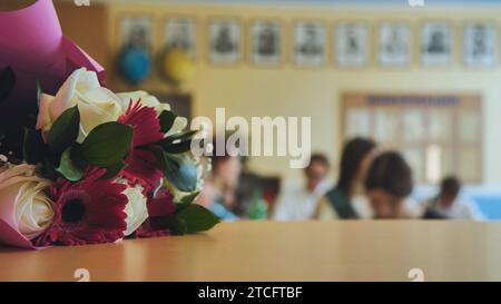 Erster Schultag. Blumen liegen auf dem Tisch, um den Schultag zu feiern. Stockfoto