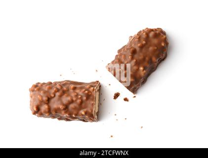 Zwei Hälften einer geschliffenen Schokoladentafel mit knusprigen Waffeln, Reisbällchen und Karamell auf weißem Hintergrund, Draufsicht. Konditorei-Konzept. Stockfoto