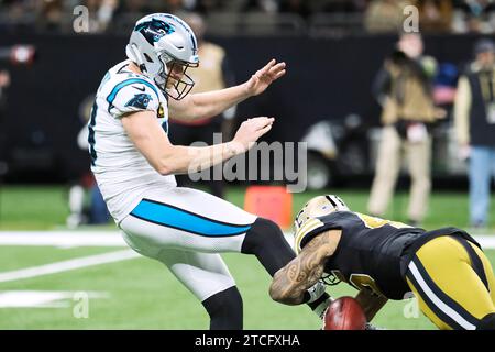 New Orleans, Louisiana, USA. Dezember 2023. (Links nach rechts) Johnny Hekker hat seinen Kick vom Linebacker Nephi Sewell der New Orleans Saints blockiert, der am 10. Dezember 2023 von den New Orleans Saints für einen Touchdown in einem NFL-Spiel in New Orleans, Louisiana, USA, zurückgebracht wurde. (Kreditbild: © Dan Anderson/ZUMA Press Wire) NUR REDAKTIONELLE VERWENDUNG! Nicht für kommerzielle ZWECKE! Stockfoto