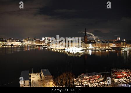 Stockholm Stadt. Keine Leute, ein paar schöne Wolken, Reflektionen im Malaren-See, Lichtreflexe in der Innenstadt, rote Boote im Vordergrund. GoranOfSchweden Stockfoto